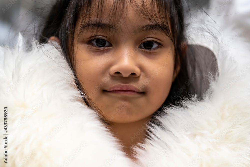 Pretty asian child wearing a white coat made of fur. Pretty asian model wearing white fur coat Pretty asian child wearing a white coat made of fur. Pretty asian model wearing white fur coat