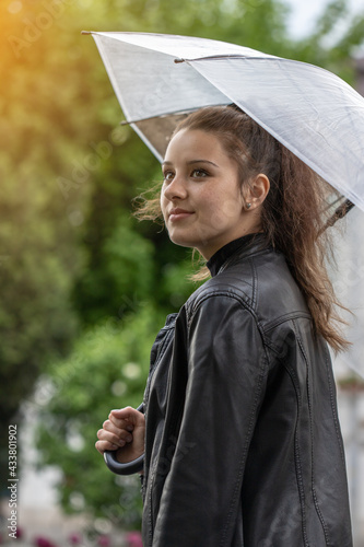 Young girl holding an umbrella in the rain