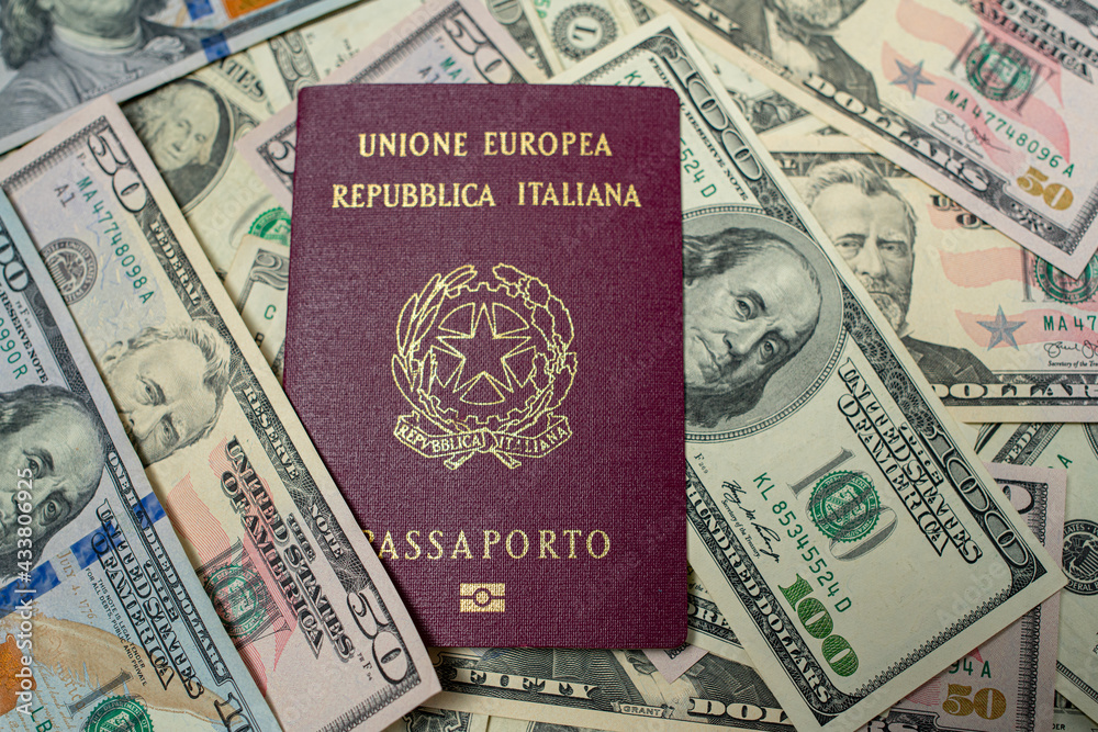 Italian Passport on top of dollar banknotes. One hundred and fifty USD bills. European Union Passport. Traveling to the United States. Italian Passport on top of dollar banknotes. One hundred and fifty USD bills. European Union Passport. Traveling to the United States.