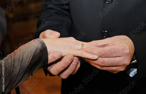 Close up view of the gold ring that the groom places on the bride's hand on her wedding day.