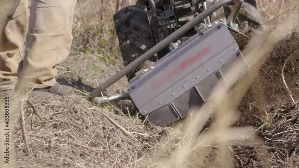 Rototiller throws topsoil about, agriculture in Sweden, slow motion close up Rototiller throws topsoil about, agriculture in Sweden, slow motion close up