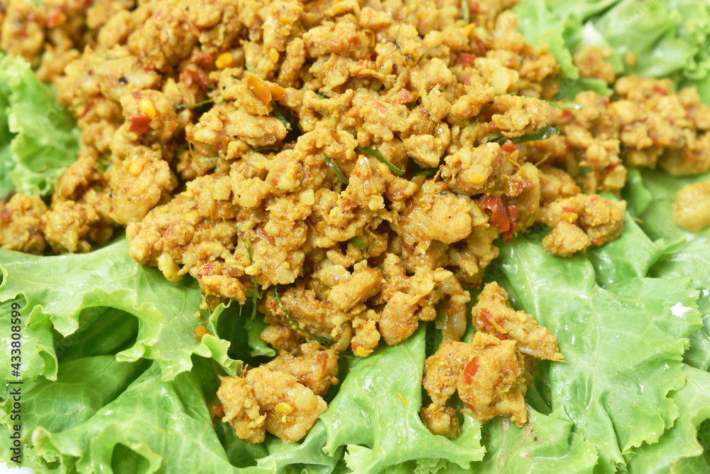 spicy fried chop pork with turmeric and curry on lettuce Thai southern style food in plate spicy fried chop pork with turmeric and curry on lettuce Thai southern style food in plate
