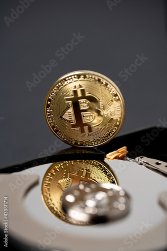 Bitcoin reflecting on hard drive platter. Crypto currency mining concept, block chain technology and ledger storing concept.