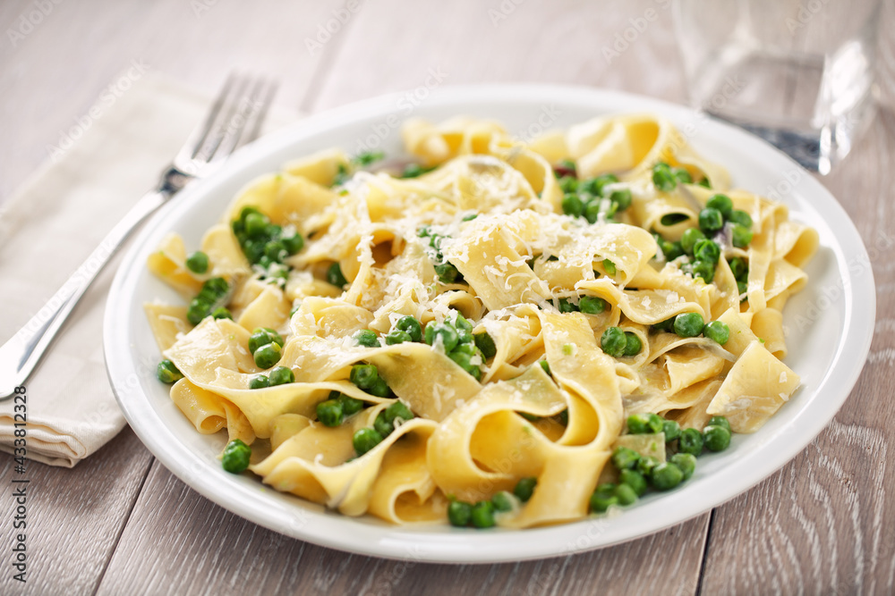Tagliatelle pasta with cream and peas on a plate.