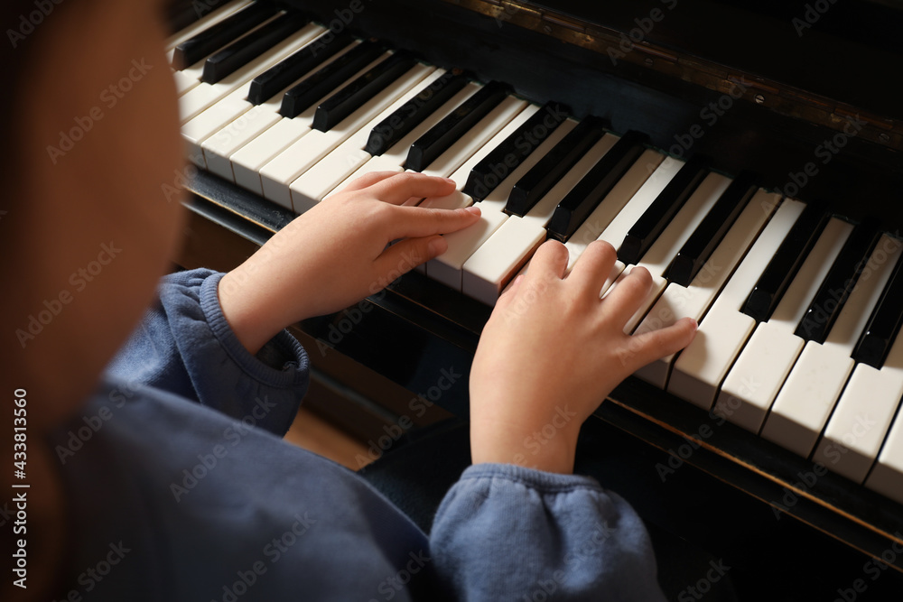 Fototapeta premium Little child playing piano, closeup. Music lesson