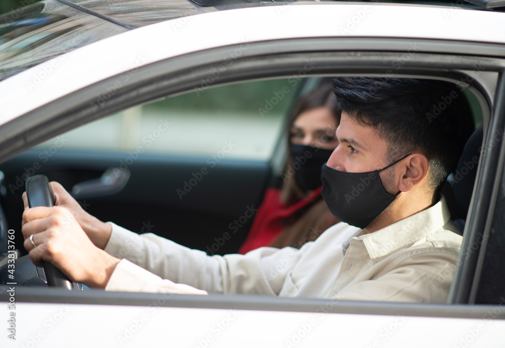 Masked couple in their car, covid coronavirus concept Masked couple in their car, covid coronavirus concept