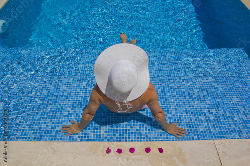  young woman in a white hat relaxing in the pool