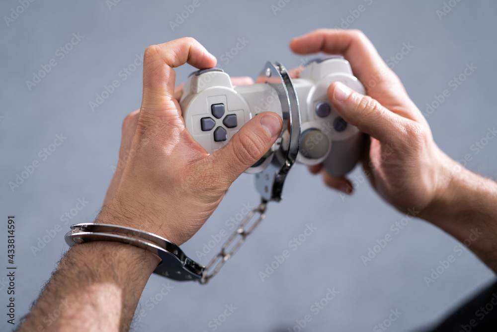 Video Game Addiction. Handcuffs and Gamepad