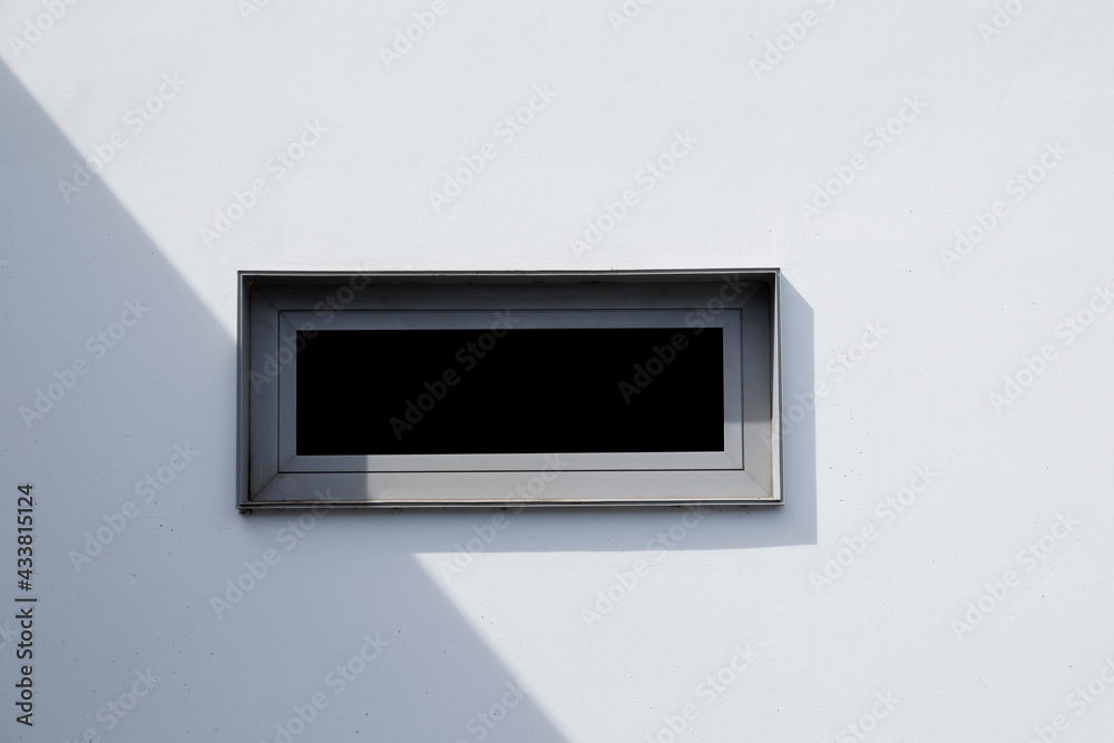 white wall with small window front and metal frame, space for informations and text, no people white wall with small window front and metal frame, space for informations and text, no people
