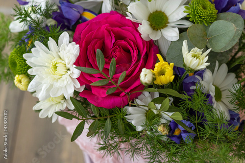 Close up bouquet with red rose  purple irises and white  yellow  green chrysanthemums. floral background.