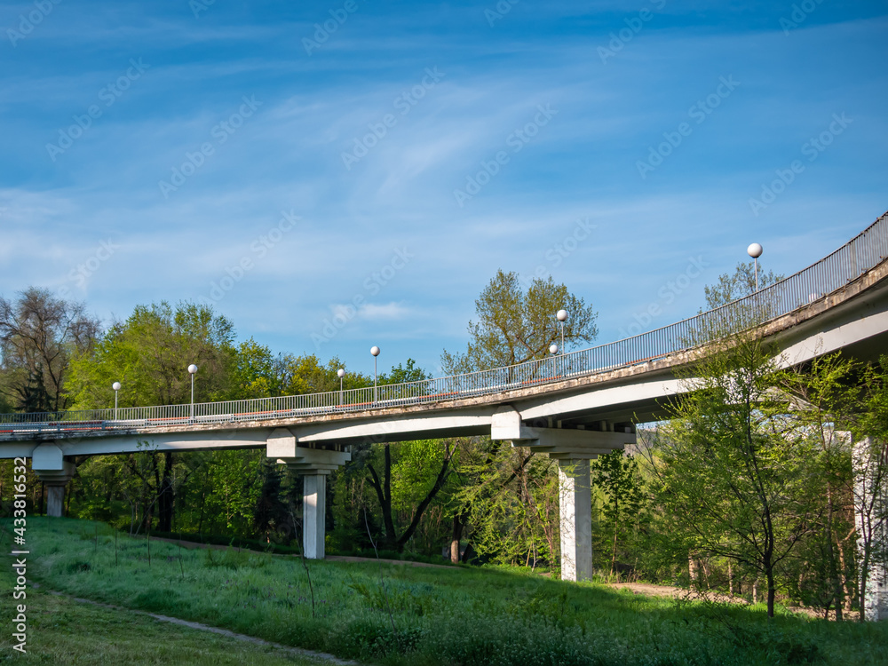 Automobile bridge on low pillars against the background of the forest and the blue sky. Automobile bridge on low pillars against the background of the forest and the blue sky.