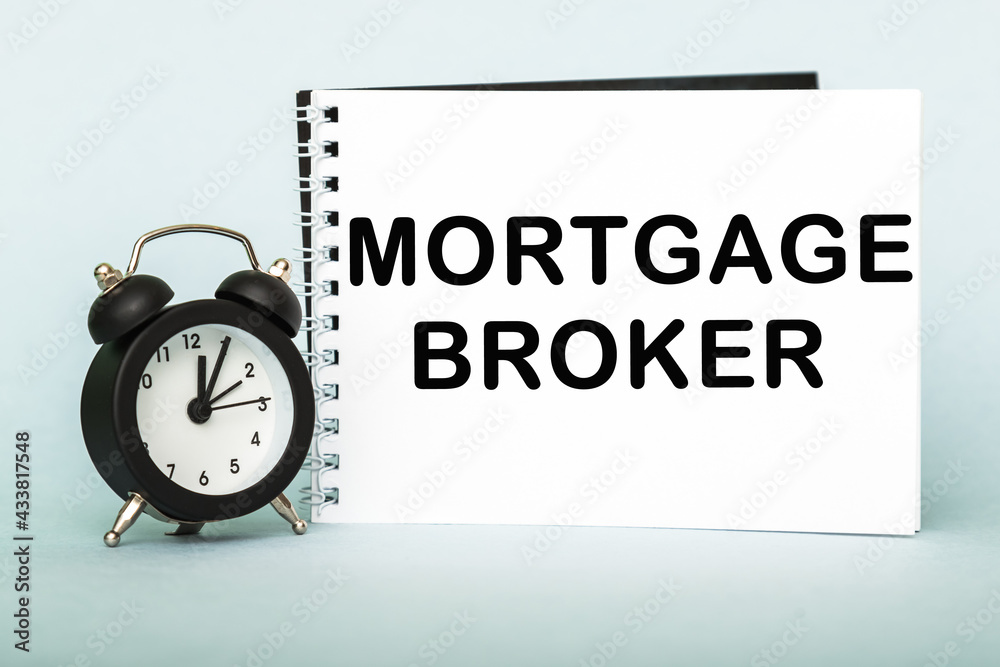 A words MORTGAGE BROKER on notebook with clock. Concept for time management and business. A words MORTGAGE BROKER on notebook with clock. Concept for time management and business.