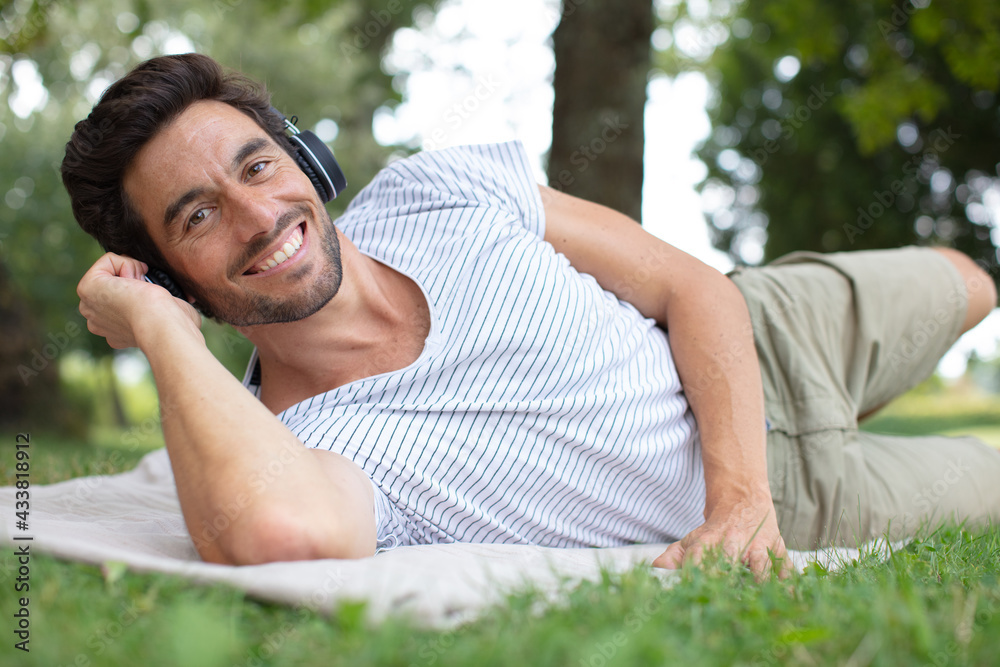 handsome man lying on the grass in park handsome man lying on the grass in park