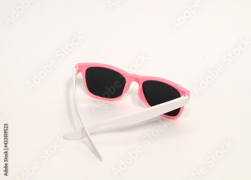 Pink plastic sunglasses isolated on gray background