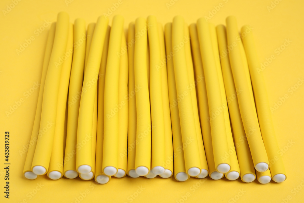 Curling rods on yellow background. Hair styling tool Curling rods on yellow background. Hair styling tool