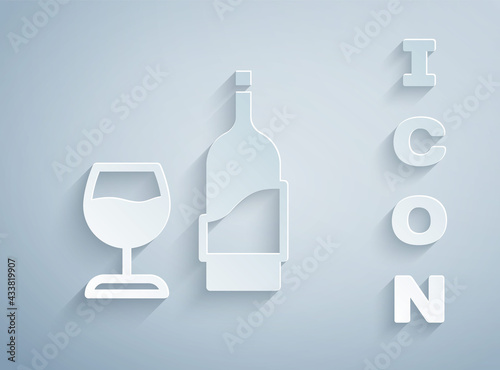 Paper cut Wine bottle with glass icon isolated on grey background. Paper art style. Vector