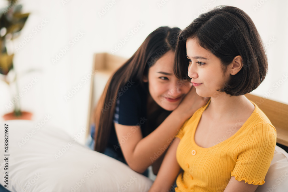 Young beautiful Asian couple love friend woman talking touchy in white bedroom at home which smiling and felling happy, LGBT woman love Travelling summer vacation trip concept. Young beautiful Asian couple love friend woman talking touchy in white bedroom at home which smiling and felling happy, LGBT woman love Travelling summer vacation trip concept.