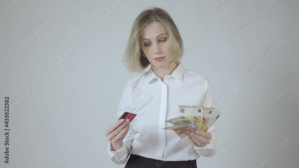 Businesswoman in white choosing between credit card and the cash. 4K video. Businesswoman in white choosing between credit card and the cash. 4K video.