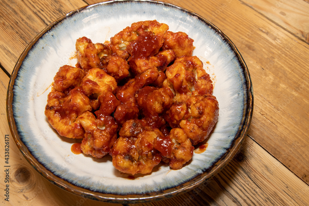 A plate of delicious Chinese style buffalo florets on a wooden kitchen table A plate of delicious Chinese style buffalo florets on a wooden kitchen table