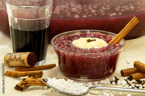 Sweet red wine sagu with cream, cloves and cinnamon in selective focus photo