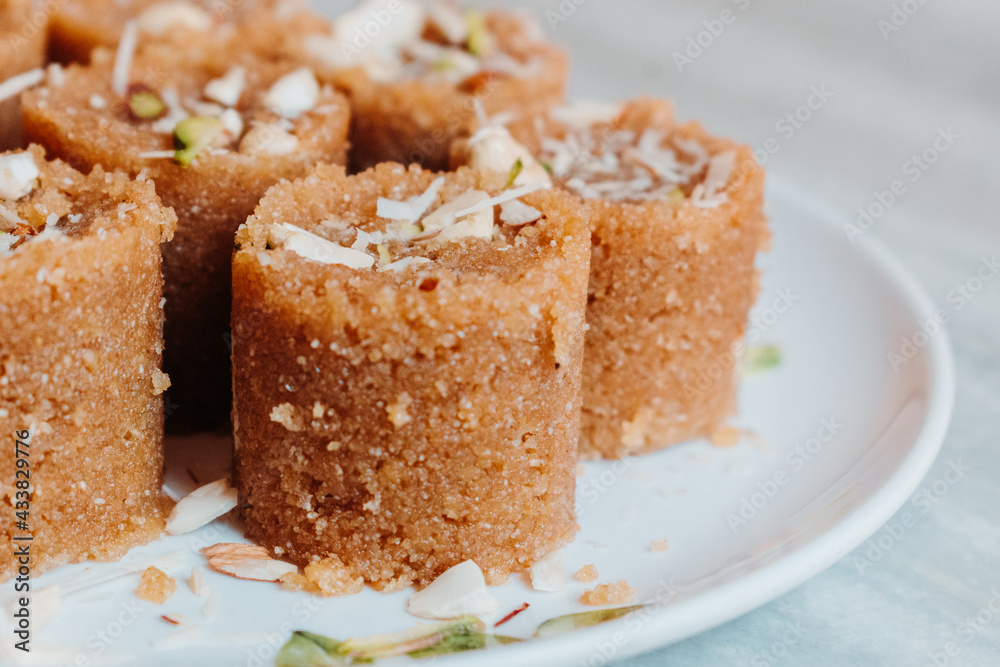 Close up of Wheat laddu - Roasted wheat flour mixed with Desi Ghee and sugar to make tasty and sweet Laddu. Served in a dish on table Close up of Wheat laddu - Roasted wheat flour mixed with Desi Ghee and sugar to make tasty and sweet Laddu. Served in a dish on table