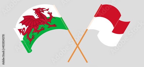 Crossed and waving flags of Wales and Indonesia