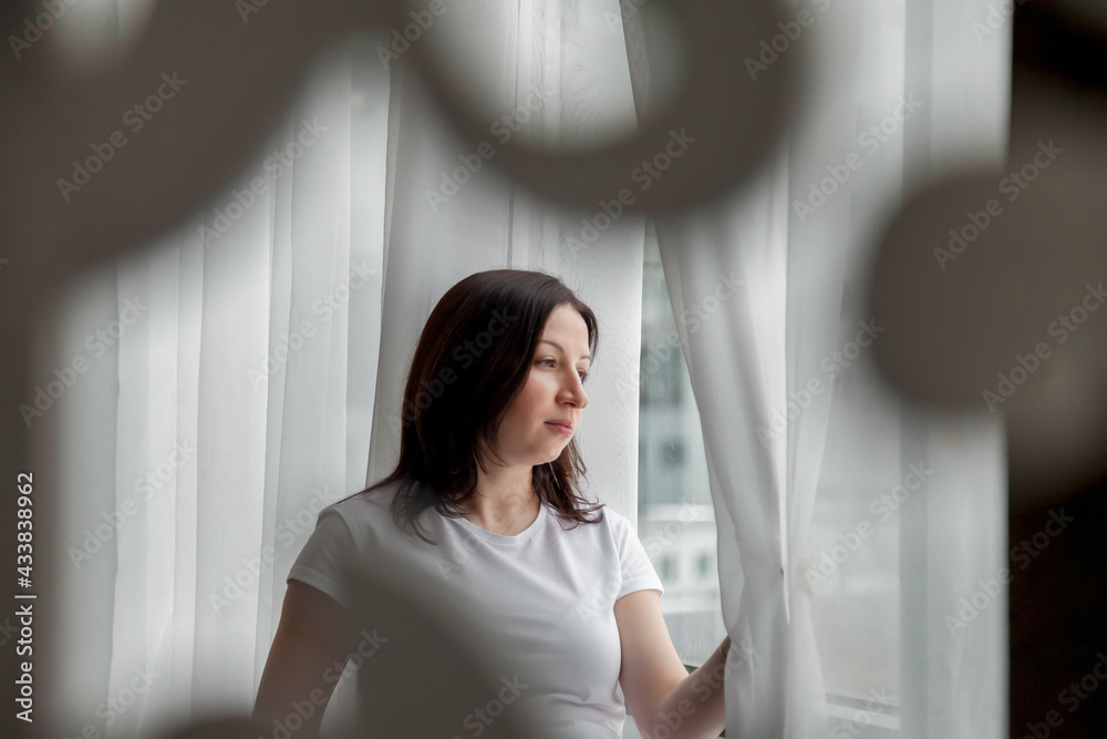 Portrait happy pregnant woman with big belly at window in home