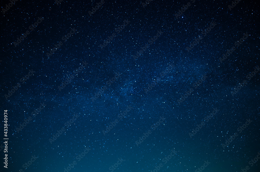 Fototapeta premium Beautiful night sky. Twinkling stars. Light clouds. Silence and eternity. Galaxy. Deep blue tones. Texture. Background. Wallpaper. There is a place for your inscription.