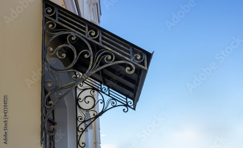 Old wrought iron awning over the door of an old house photo