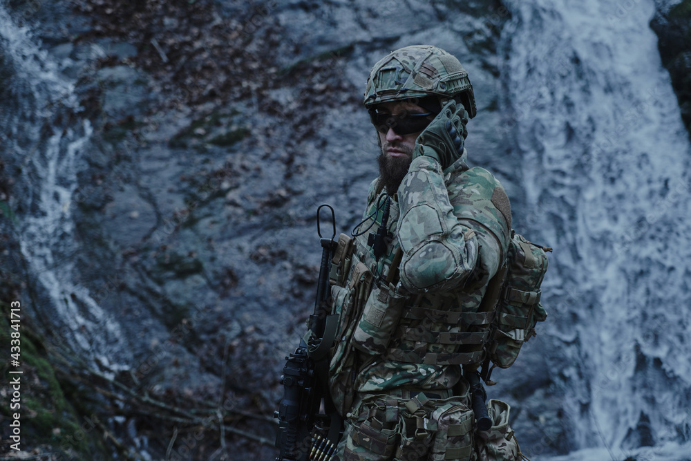 Portrait of airsoft player in professional equipment with machine gun in the forest. Soldier with weapons at war Portrait of airsoft player in professional equipment with machine gun in the forest. Soldier with weapons at war