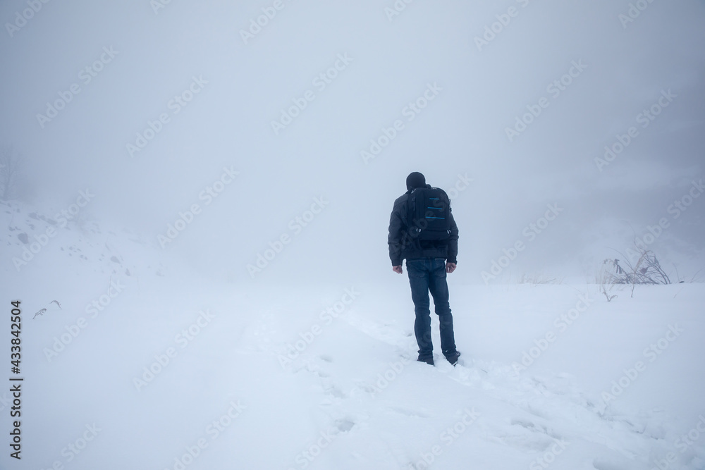 man walks in snowy field