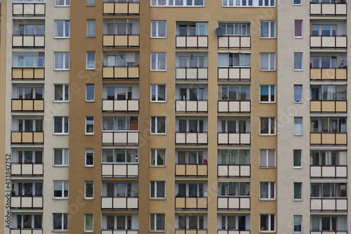 Urban stone jungle. Multiple windows on a large building in the city. Fragment of the facade of high-rise residential buildings. 