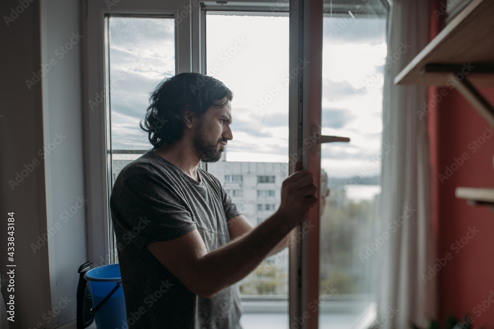 A man washes windows at home A man washes windows at home