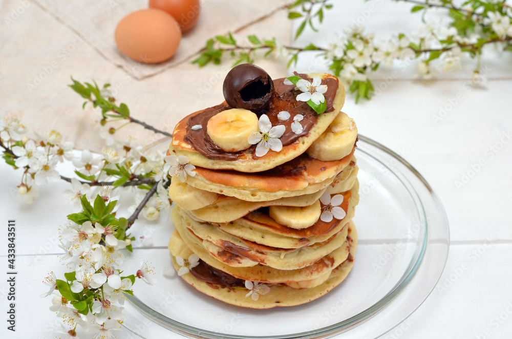 pancakes and branches of blossoming cherry on the table pancakes and branches of blossoming cherry on the table