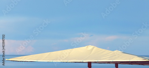 Parasol Top Closeup View On Sea Beach. Seascape With Blue Sky And Claim Sea Water. Beach Umbrellas Or Sunshade Top. Canopy, Awning, Tent Detail.
