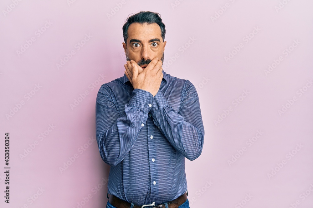 Middle age man with beard and grey hair wearing business clothes shocked covering mouth with hands for mistake. secret concept. Middle age man with beard and grey hair wearing business clothes shocked covering mouth with hands for mistake. secret concept.