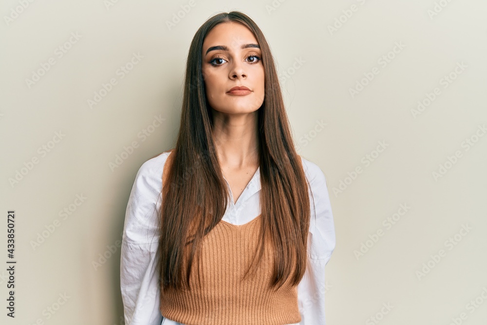 Obraz premium Beautiful brunette young woman wearing casual clothes relaxed with serious expression on face. simple and natural looking at the camera.