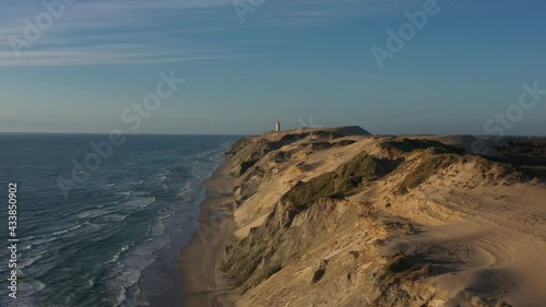 Drone Flight Over Coastline To Rubjerg Knude Lighthouse, Hjorring, Denmark photo