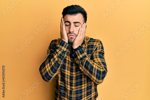 Wallpaper Mural Young hispanic man wearing casual clothes tired hands covering face, depression and sadness, upset and irritated for problem Torontodigital.ca