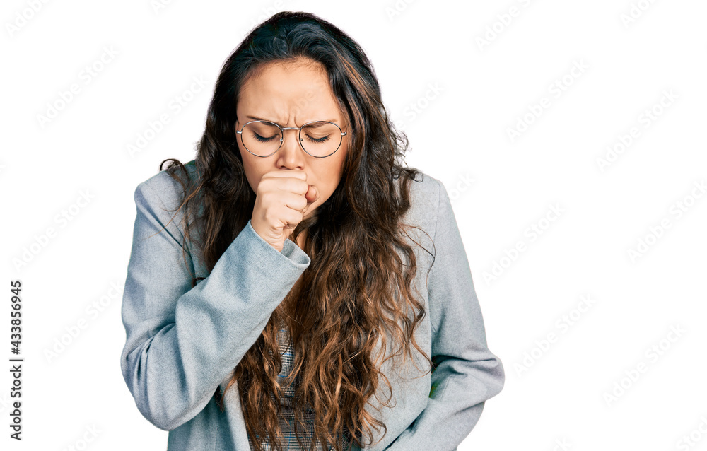 Young hispanic girl wearing business clothes and glasses feeling unwell and coughing as symptom for cold or bronchitis. health care concept. Young hispanic girl wearing business clothes and glasses feeling unwell and coughing as symptom for cold or bronchitis. health care concept.