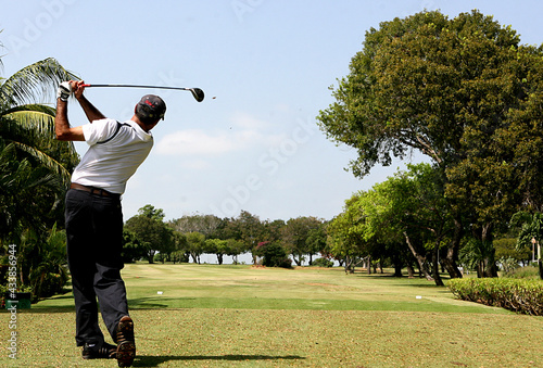 Obraz na plátně Un jugador de golf luego de dar su golpe en la salida del tee