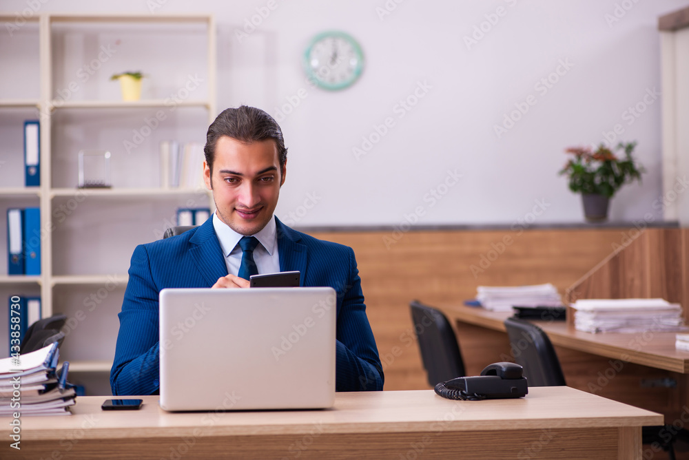 Young male employee working in the office Young male employee working in the office