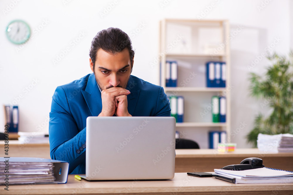 Young male employee and too many work in the office Young male employee and too many work in the office