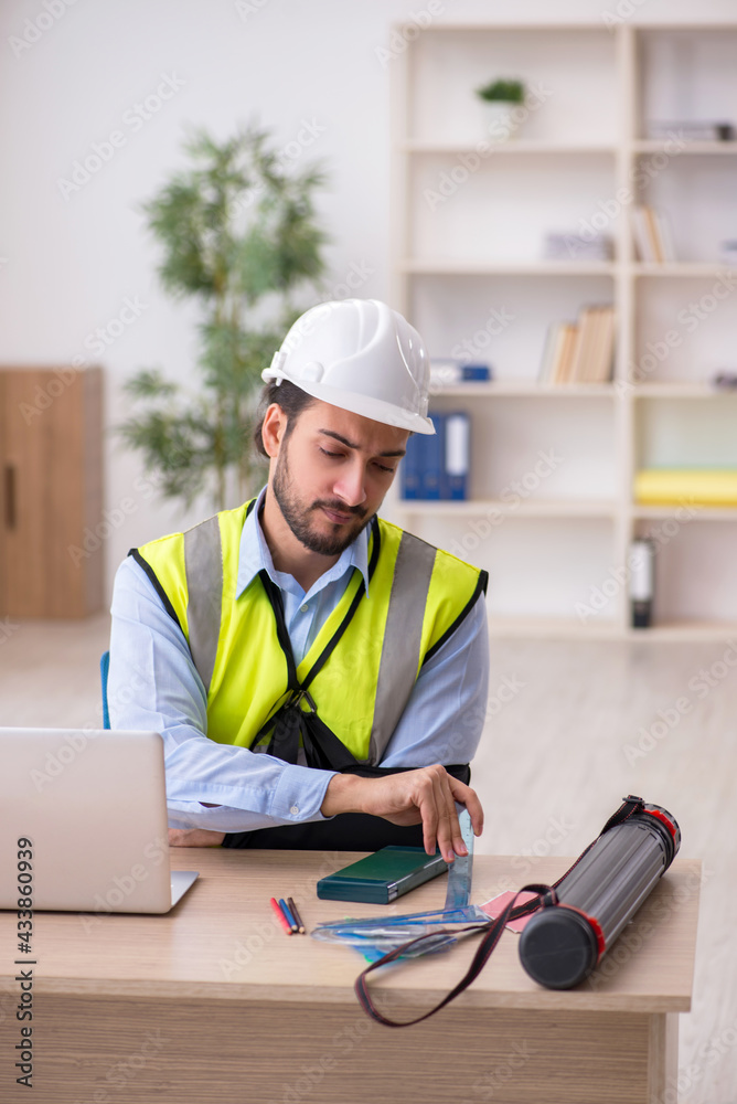 Young arm injured male architect working in the office Young arm injured male architect working in the office