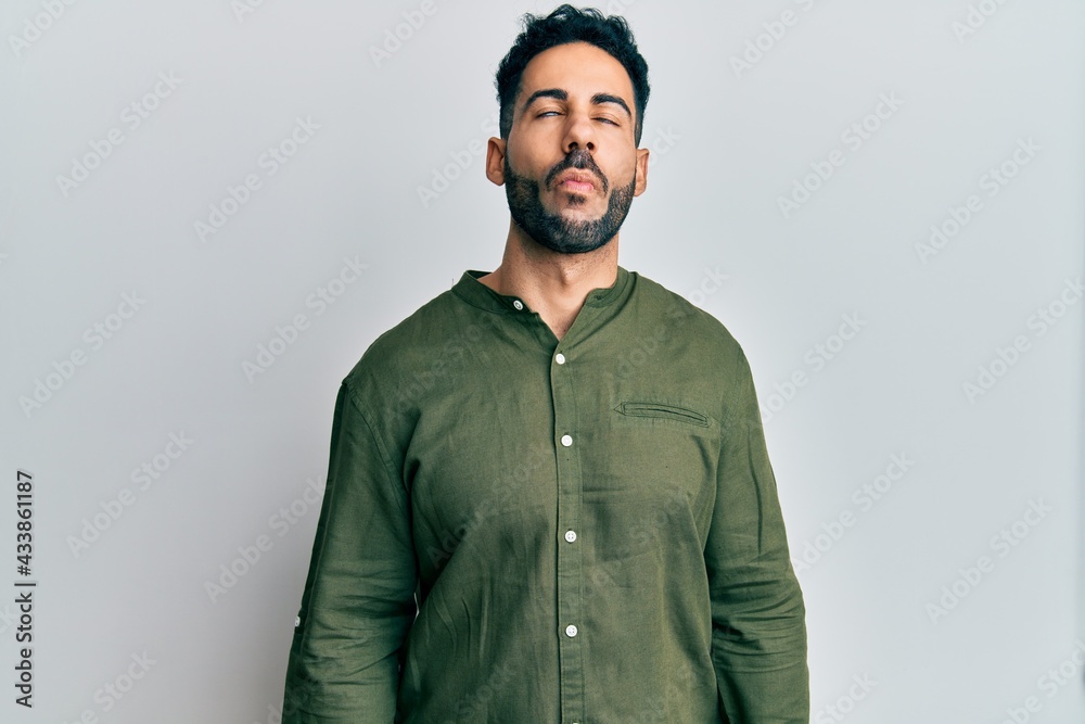 Obraz premium Young hispanic man wearing casual clothes making fish face with lips, crazy and comical gesture. funny expression.
