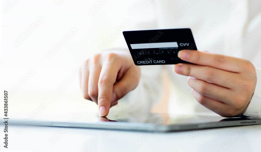 Close up woman hand using credit card and tablet for buying online shopping at home ,payment,buying and online shopping concept. Close up woman hand using credit card and tablet for buying online shopping at home ,payment,buying and online shopping concept.