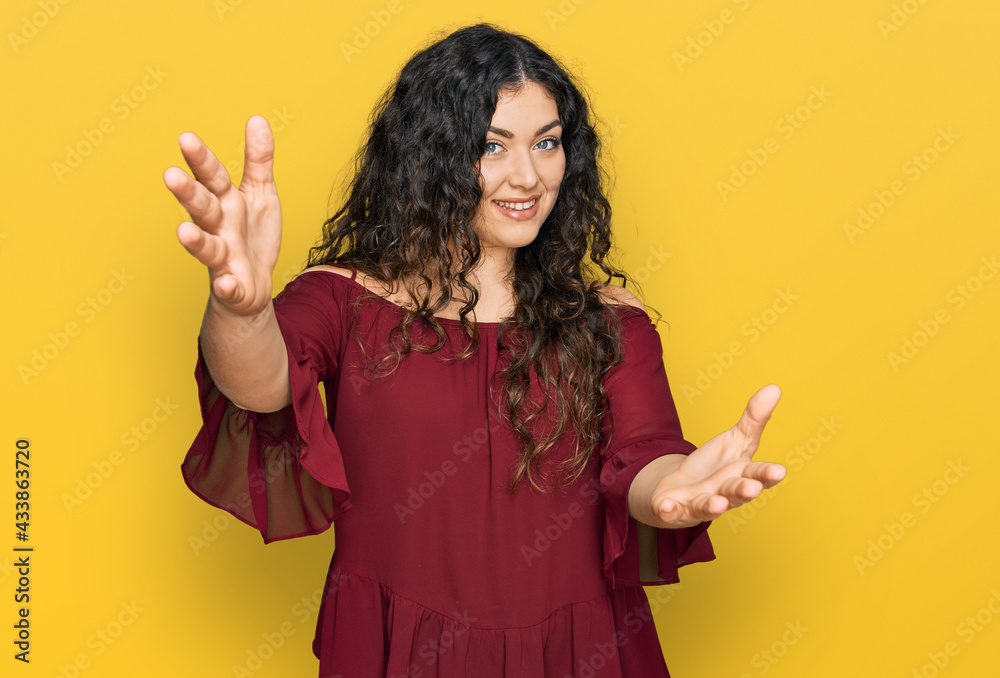 Young hispanic girl wearing casual clothes looking at the camera smiling with open arms for hug. cheerful expression embracing happiness.