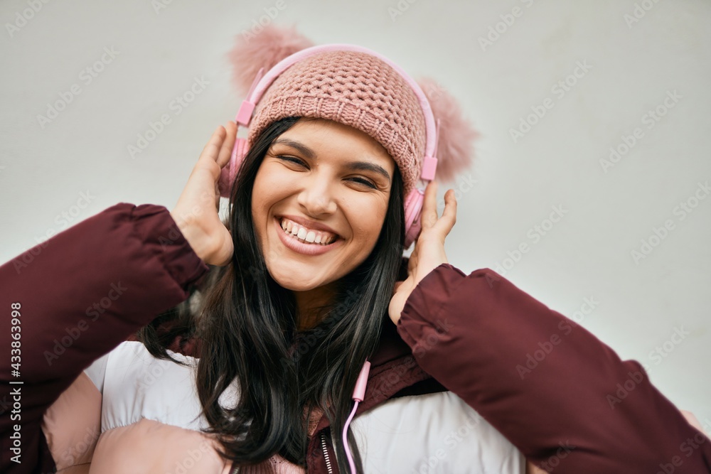 Young hispanic girl smiling happy using headphones at the city. Young hispanic girl smiling happy using headphones at the city.