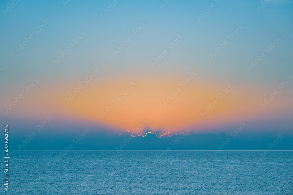 Sun rising over sea