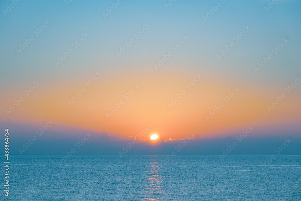 Fototapeta premium Sun rising over sea